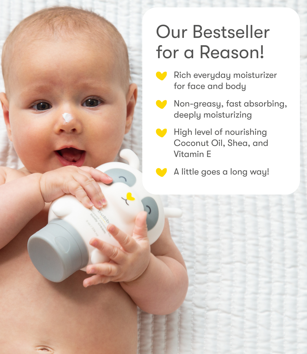 Baby holding a Bubbsi Whipped Coconut Oil Body Cream bottle with product features listed on the right.