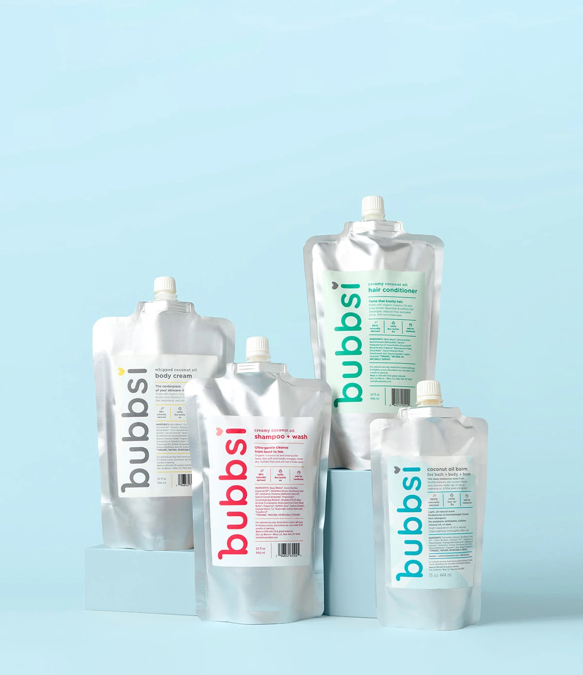 Bubbsi value size refill pouches for Whipped Coconut Oil Body Cream, Shampoo + Wash, Hair Conditioner, and Oil Balm on a light blue background