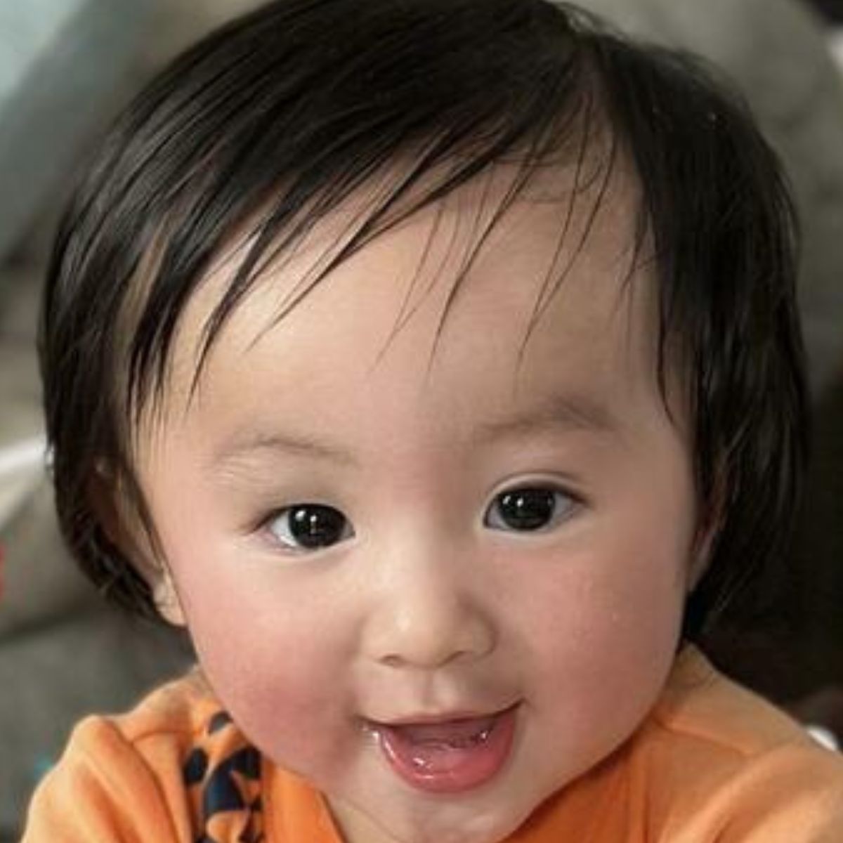 Child with a happy expression and cured rash wearing an orange shirt