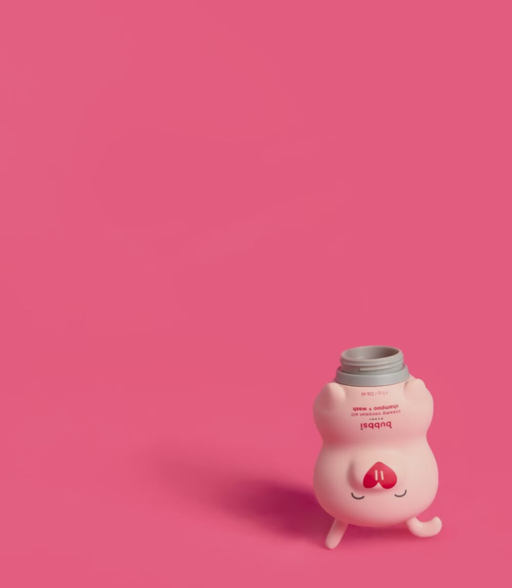 Bubbsi creamy coconut oil shampoo and wash value refill 32 oz pouch filling the 8oz pink Bubbsi bottle on a hot pink background